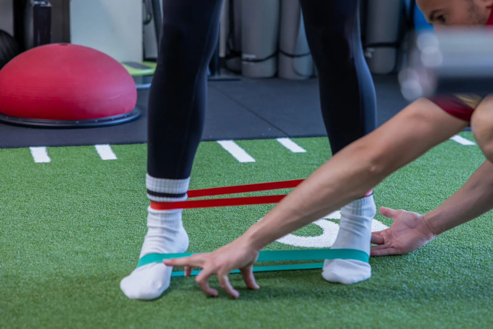 Physioanalyse: Beinachse und Kniekontrolle bei einer Übung mit Miniband