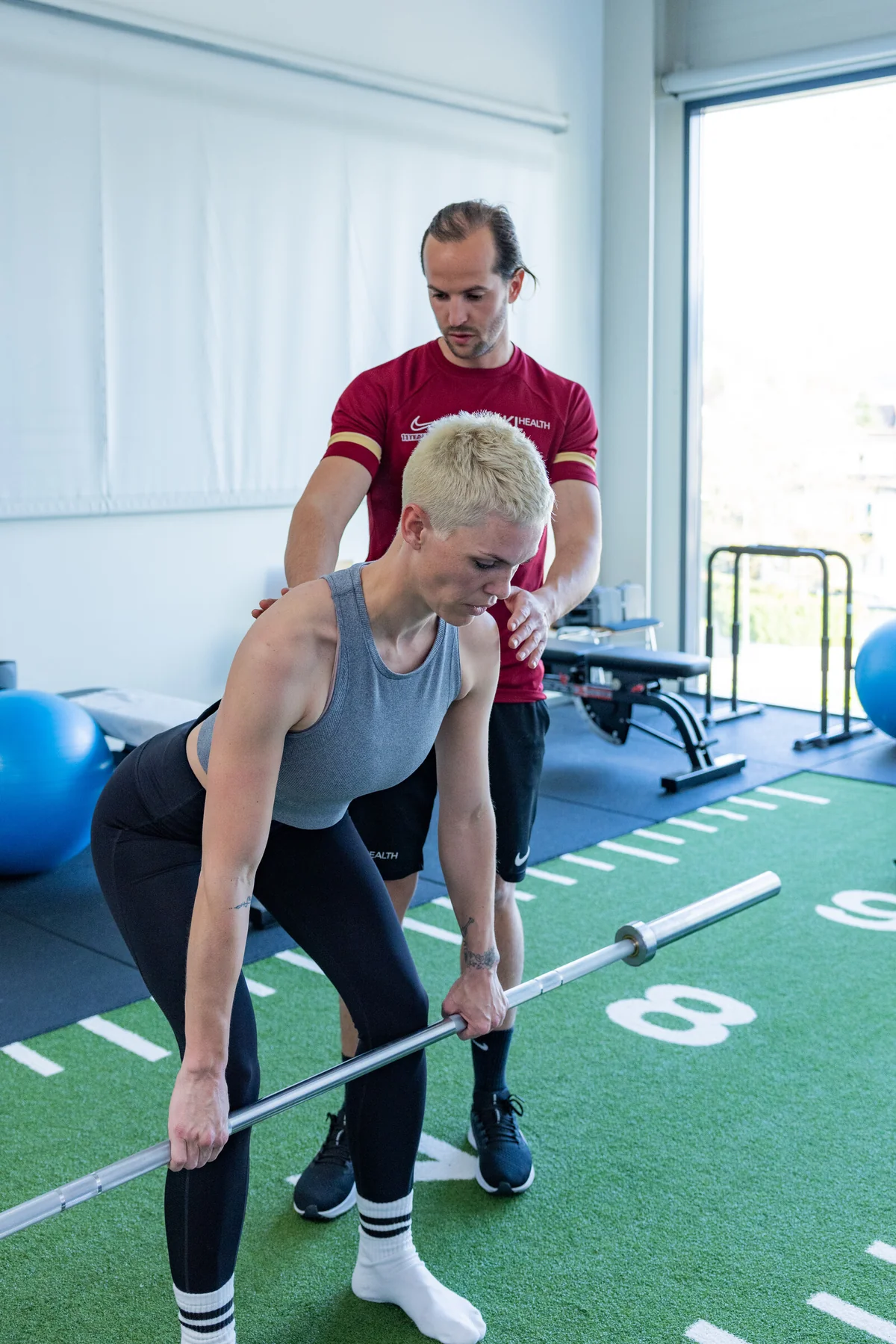 Coach begleitet eine Klientin beim Kreuzheben
